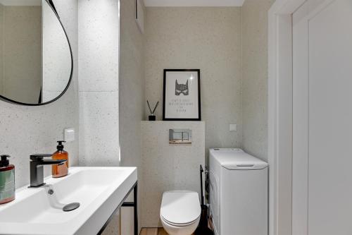 格但斯克Downtown Apartments Garnizon的浴室配有白色卫生间和盥洗盆。
