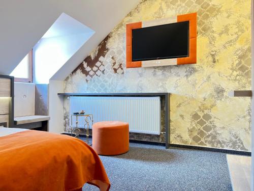 锡比乌Loft by Lumiere Sibiu的一间卧室配有一张床,墙上配有电视