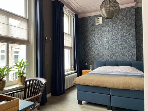 OudenboschBed & Breakfast By Genck的一间卧室设有蓝色的床和2个窗户。
