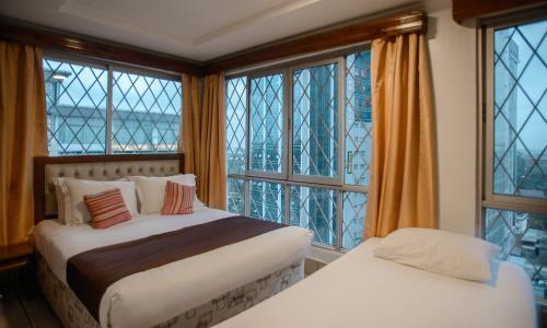 内罗毕钻石广场公寓式酒店的一间卧室设有两张床和大窗户