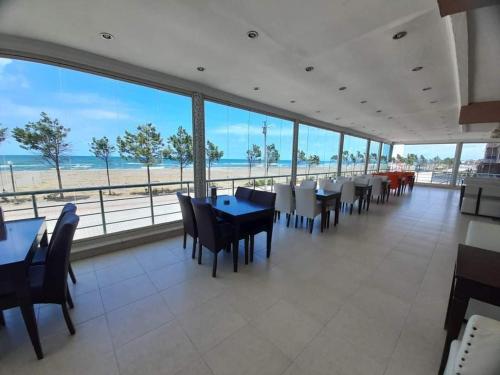 萨卡里亚Kocaali Sun Otel的一个带桌椅的餐厅和海滩
