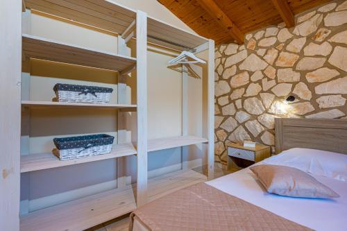 凯里翁Arca Villa - Enchanting Sunset!的一间卧室设有一张床和石墙