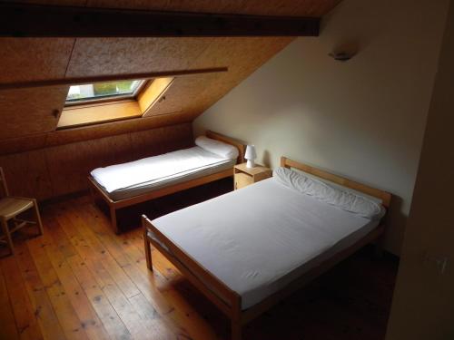 LuzenacCamping Le Castella的一间小卧室,配有两张床和窗户