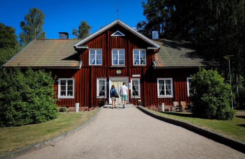 LinnerydSTF Korrö Hotell的两个人站在一个红色房子前面