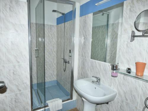 圣玛丽亚Hotel MiraBela的一间带水槽和玻璃淋浴的浴室