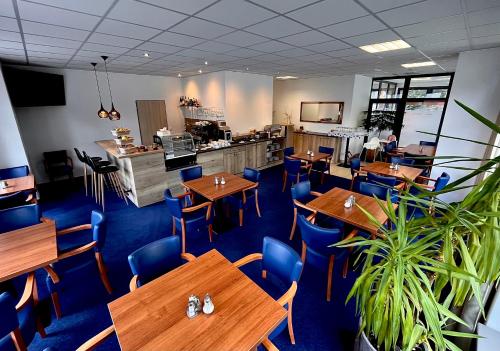 瓦拉什斯凯梅济日奇Sport HOTEL Centrum的餐厅设有木桌和蓝色椅子