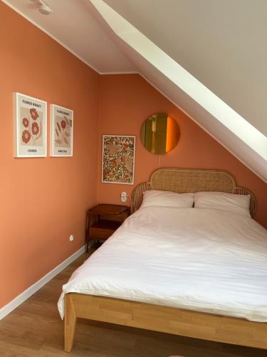 DziemianySlow Home的一间卧室拥有橙色的墙壁和一张大床