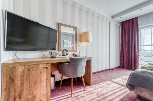 克拉科夫秋千酒店的酒店客房设有一张带大电视的书桌