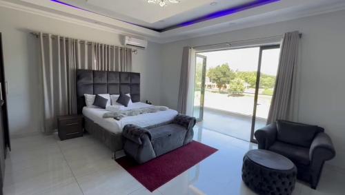 弗里尼欣Lifestyle Lodge Hotel的卧室配有床、椅子和窗户。