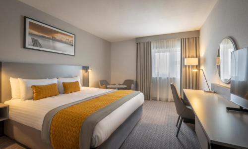 阿德格罗夫贝尔法斯特国际机场马尔丹酒店的酒店客房设有一张大床和一张书桌。