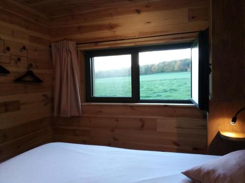 奥埃La Bucolique de Tahier的小木屋内一间卧室,带窗户