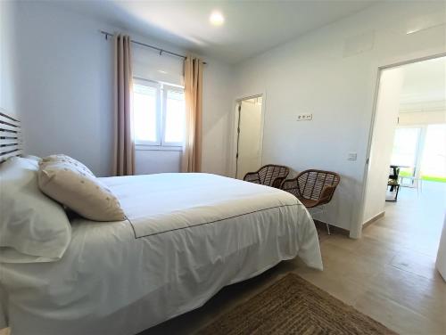 科尼尔-德拉弗龙特拉Villas Florida的卧室配有白色的床、窗户和椅子