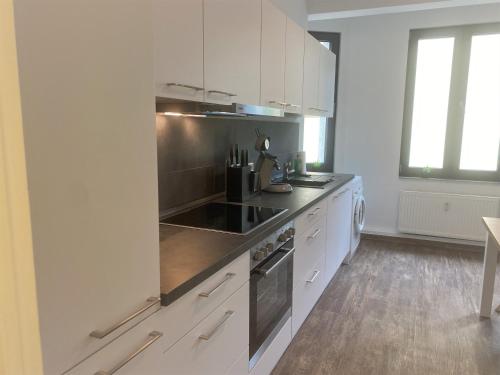 比勒费尔德Art-Appartement的厨房配有白色橱柜和炉灶烤箱。