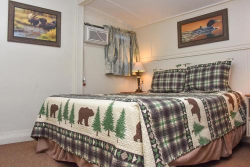 乔治湖Adirondack Sunrise Lodge的一间卧室配有一张床铺,床上有毯子,里面还有动物