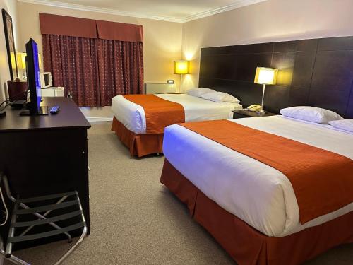 Bécancour贝坎库尔汽车旅馆的酒店客房设有两张床和一台平面电视。