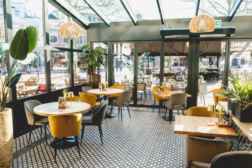 阿森City Hotel de Jonge的餐厅设有桌椅和窗户。
