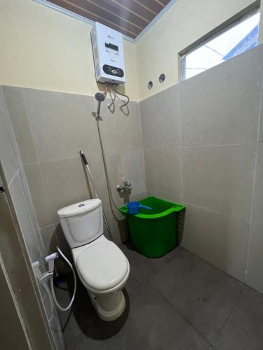 不拉士打宜Ulina Villa Segitiga Berastagi的浴室设有卫生间和绿色垃圾箱