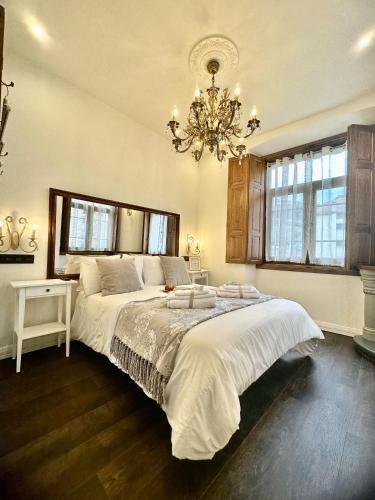 坎加斯德尔纳尔塞亚CLAREN´S BOUTIQUE ROOMS的一间卧室配有一张大床和一个吊灯。