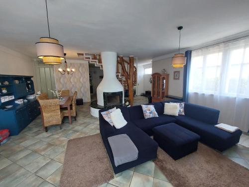凯斯特海伊Bajcsyház Apartman的客厅设有蓝色的沙发和壁炉