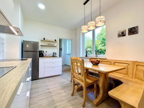 莫济列Creekside House K的厨房配有木桌、椅子和柜台。