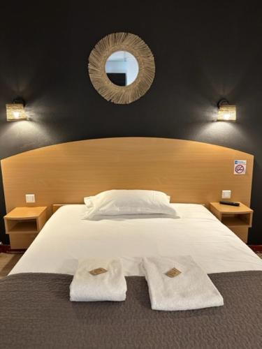 瓦朗斯里昂酒店的一间卧室配有一张床,上面有两条毛巾