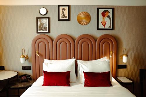 贝尔格莱德Hotel Indigo Belgrade, an IHG Hotel的一间卧室配有一张大床和两个红色枕头