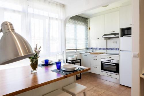 苏安塞斯Solar Home的厨房配有白色橱柜和木桌