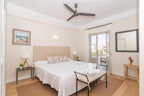 卡拉圣维森特Boutique Hotel Oriola的白色卧室配有床和吊扇