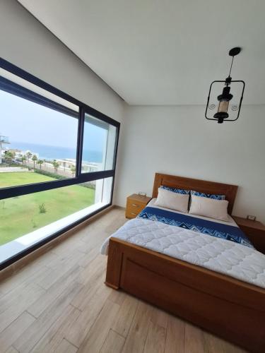 西迪布克纳德尔prestigia plage des nation的一间卧室设有一张床和一个大窗户