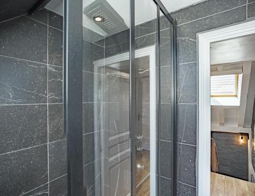 特鲁瓦Le Rooftop - vue Cathédrale - Climatisation的浴室设有玻璃淋浴间,铺有黑色瓷砖