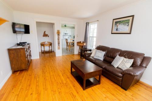 Reidville喀什拉皮的度假屋的客厅配有棕色皮沙发和桌子