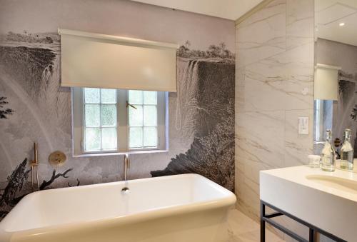 维多利亚瀑布维多利亚瀑布酒店的带浴缸、水槽和窗户的浴室