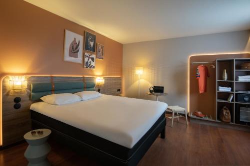 孔格林宜必思高尔夫圣特洛佩兹酒店的卧室配有一张白色大床