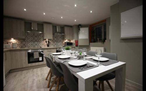 曼彻斯特Eccles的厨房配有桌椅和桌子。