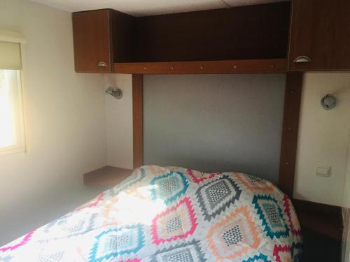 塞里尼昂Mobil-home sur terrain privé的一间卧室配有一张带木制床头板的床