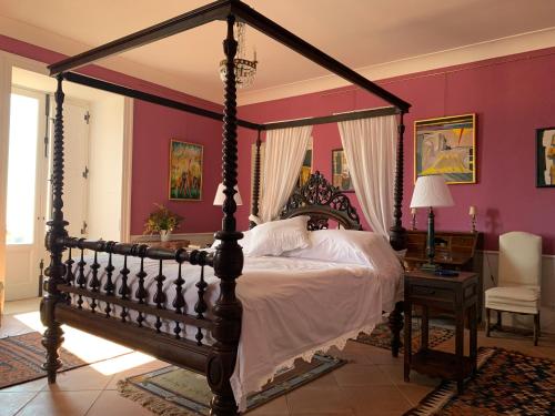 阿曼泰阿Palazzo Carratelli的一间卧室配有一张大天蓬床和一张书桌