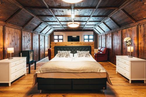 捷克克鲁姆洛夫兹拉季安德尔酒店的一间卧室设有一张大床和木墙
