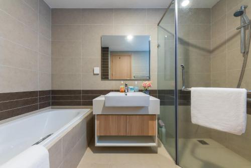 胡志明市YO's Homes Rivergate Apartment Infinity Pool Near District 1的带浴缸、水槽和淋浴的浴室