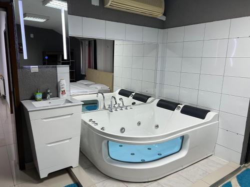GnjilaneFamily White Hotel的带浴缸和盥洗盆的浴室