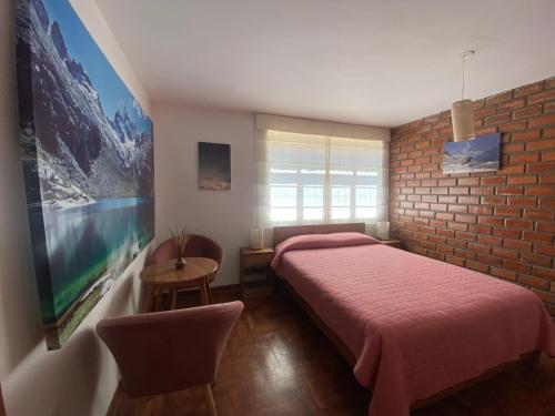 瓦拉斯Amelita Hotel Boutique的一间卧室设有红色的床和砖墙