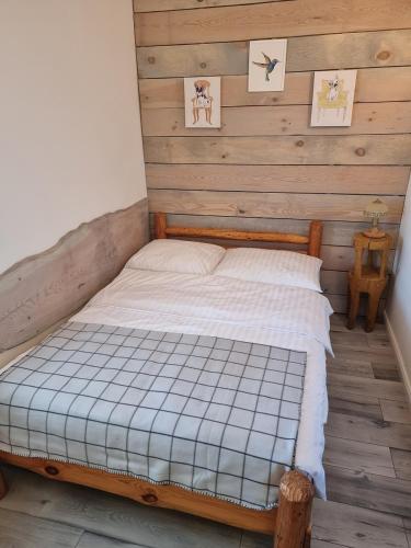 米科瓦伊基Pokoje Apartament LUX的木墙客房的一张床位