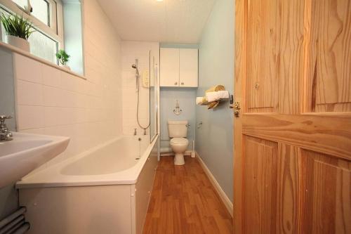 米尔顿凯恩斯Stunning 1-Bed Apartment in Milton Keynes的浴室配有卫生间、浴缸和水槽。