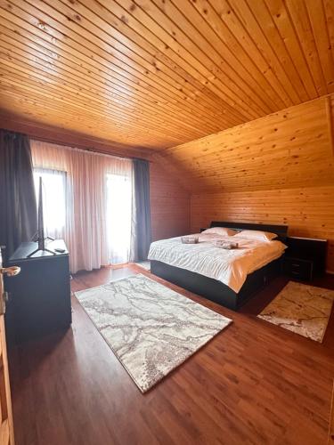 布什泰尼Ollie's Mountain Chalet的一间卧室设有一张床和木制天花板