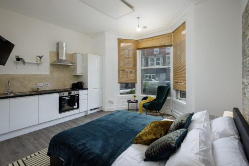 布莱克浦Seaside Suite 1 - Beautiful Long Stay Studio on Lord Street的一间卧室配有一张床和一间厨房