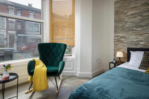 布莱克浦Seaside Suite 1 - Beautiful Long Stay Studio on Lord Street的卧室配有床、椅子和窗户。