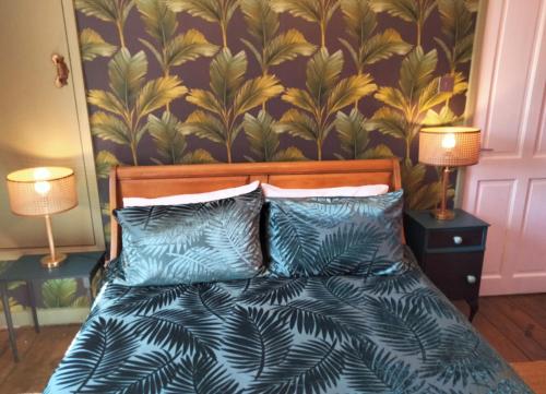 吉斯伯勒Garden Cottage的一间卧室配有一张带蓝色枕头的床和壁纸