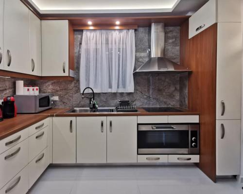 雅典Keti's home的厨房配有白色橱柜、水槽和微波炉