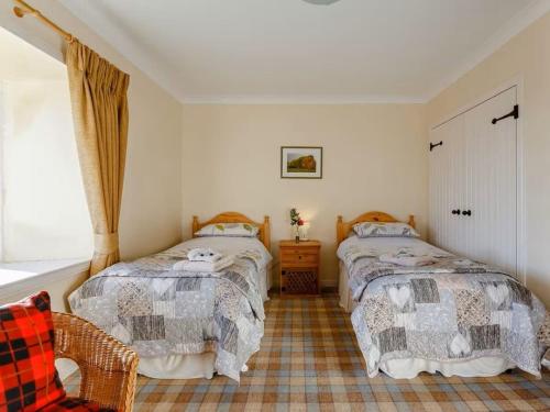 LatheronCraiglea Lodge & Barn的一间卧室设有两张床和窗户。