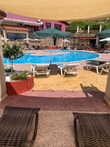 Sidhirokhórion罗家斯酒店的一个带椅子和遮阳伞的大型游泳池