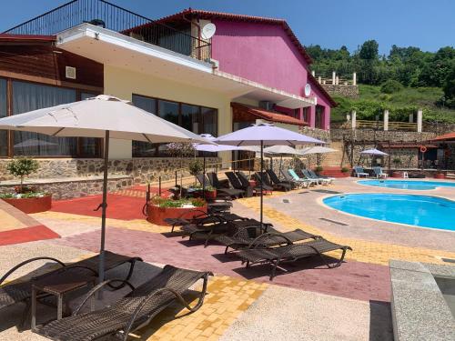 Sidhirokhórion罗家斯酒店的一个带椅子和遮阳伞的度假村和一个游泳池
